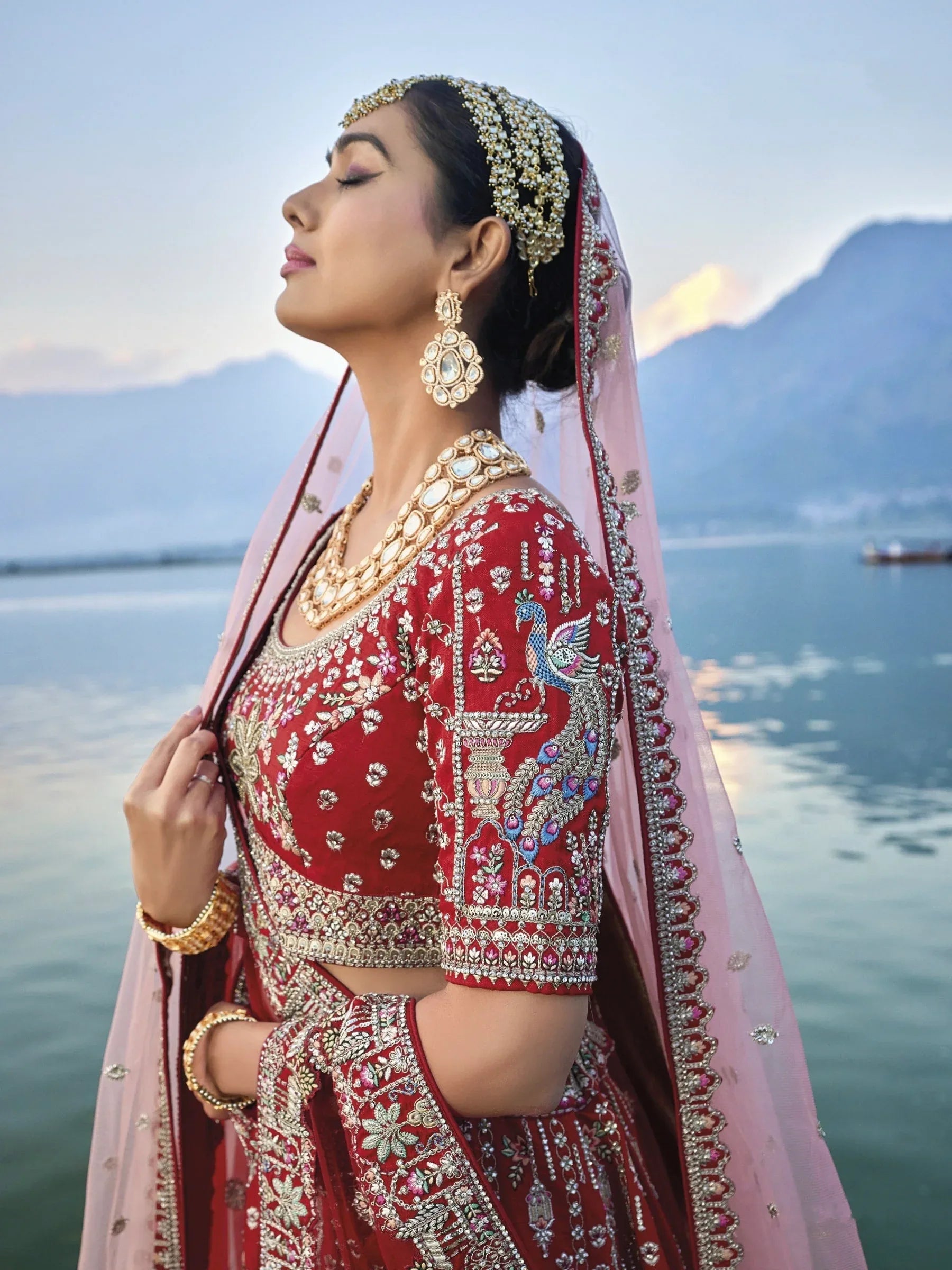 Exquisite red silk bridal lehenga with intricate embroidery and heavy net dupatta.