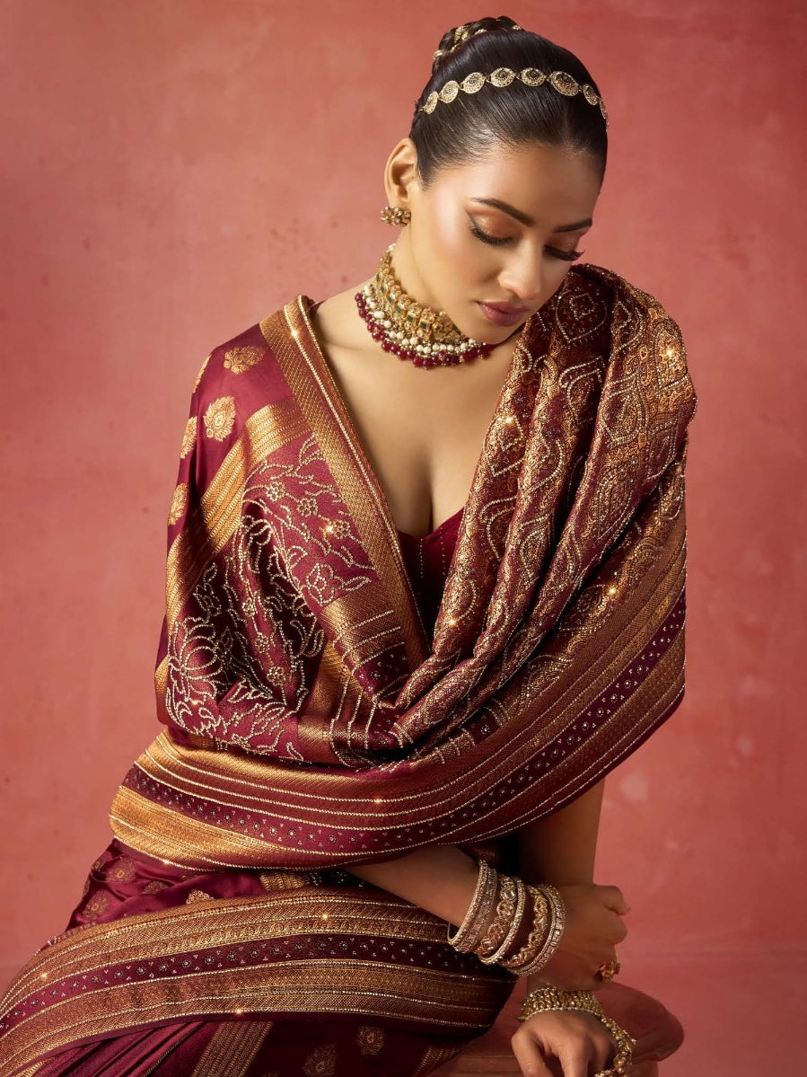 Model wearing maroon bridal saree with intricate work