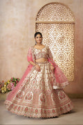 Traditional Indian bridal outfit featuring white lehenga and pink dupatta