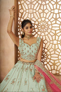 Bridal green lehenga in zari silk featuring handcrafted peacock motifs