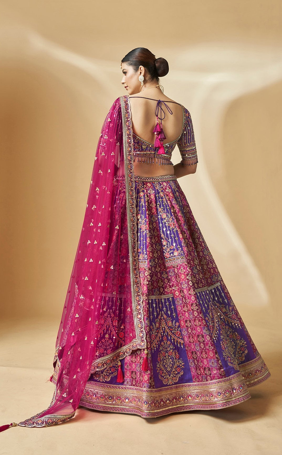 Festive pink and purple lehenga choli with heavy embroidery and tassels