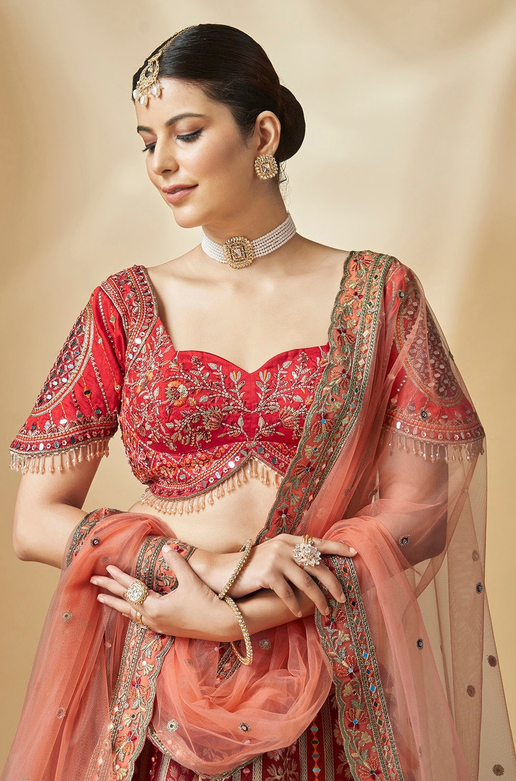 Designer lehenga choli in rich red with intricate zari embroidery and tassel details
