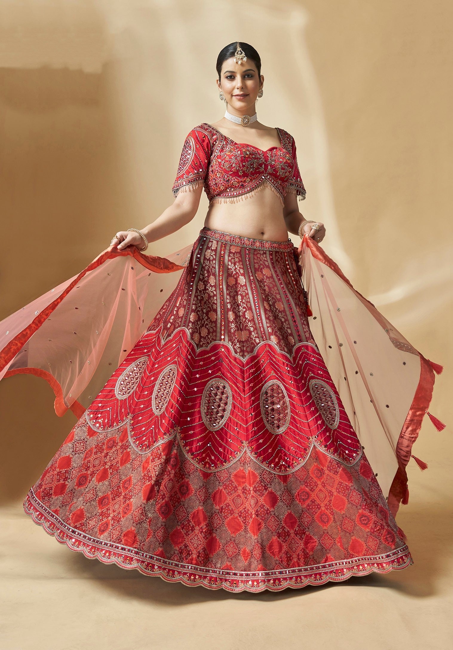 Festive lehenga choli in vibrant red with elegant dupatta and handcrafted embellishments