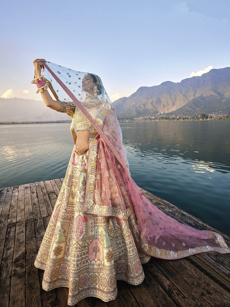 Woman in off-white silk lehenga with embroidered peach dupatta by a lake.