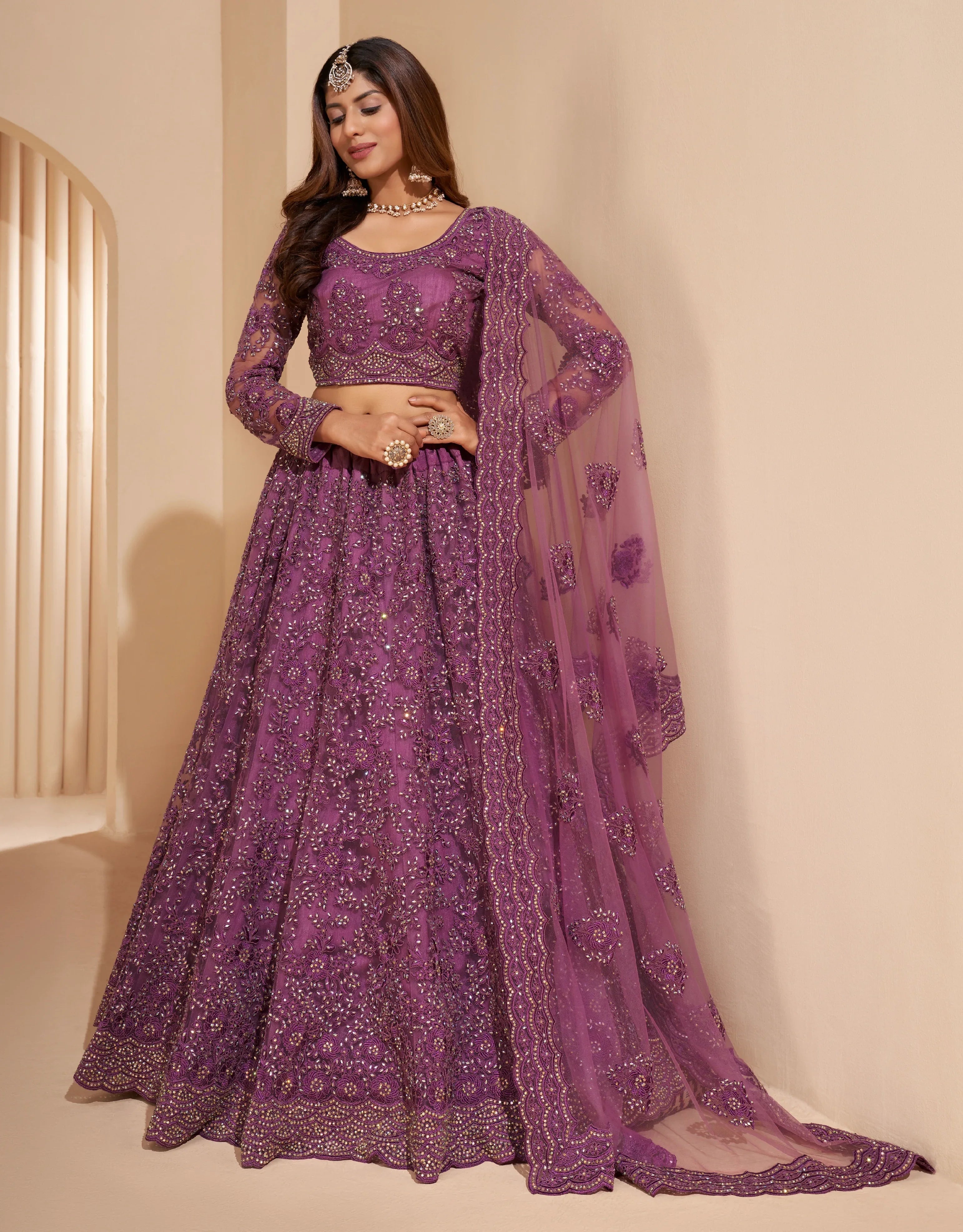 Elegant dark orchid net lehenga with silk inner and thread &amp; cording embroidery.