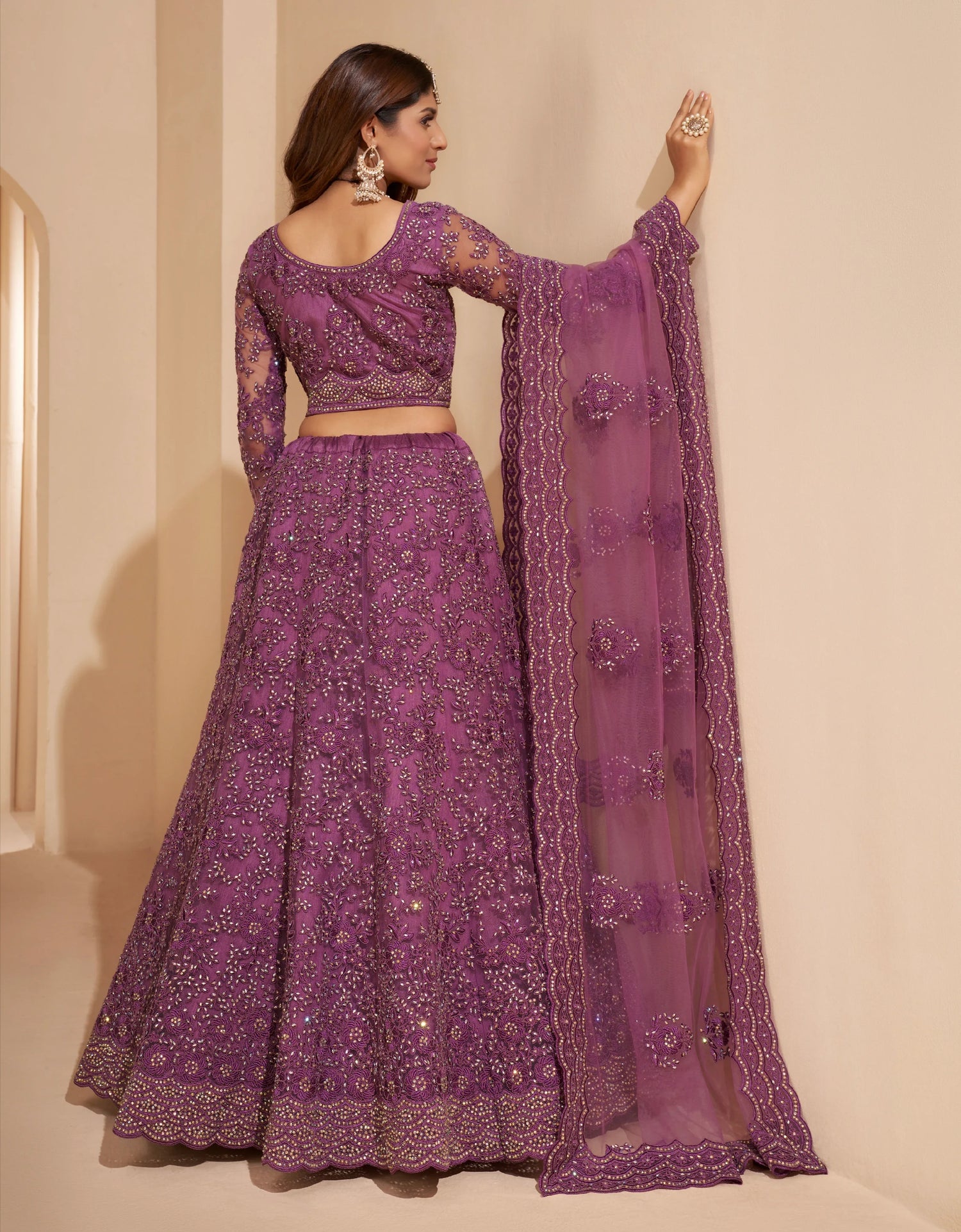 Elegant dark orchid net lehenga with silk inner and thread &amp; cording embroidery.