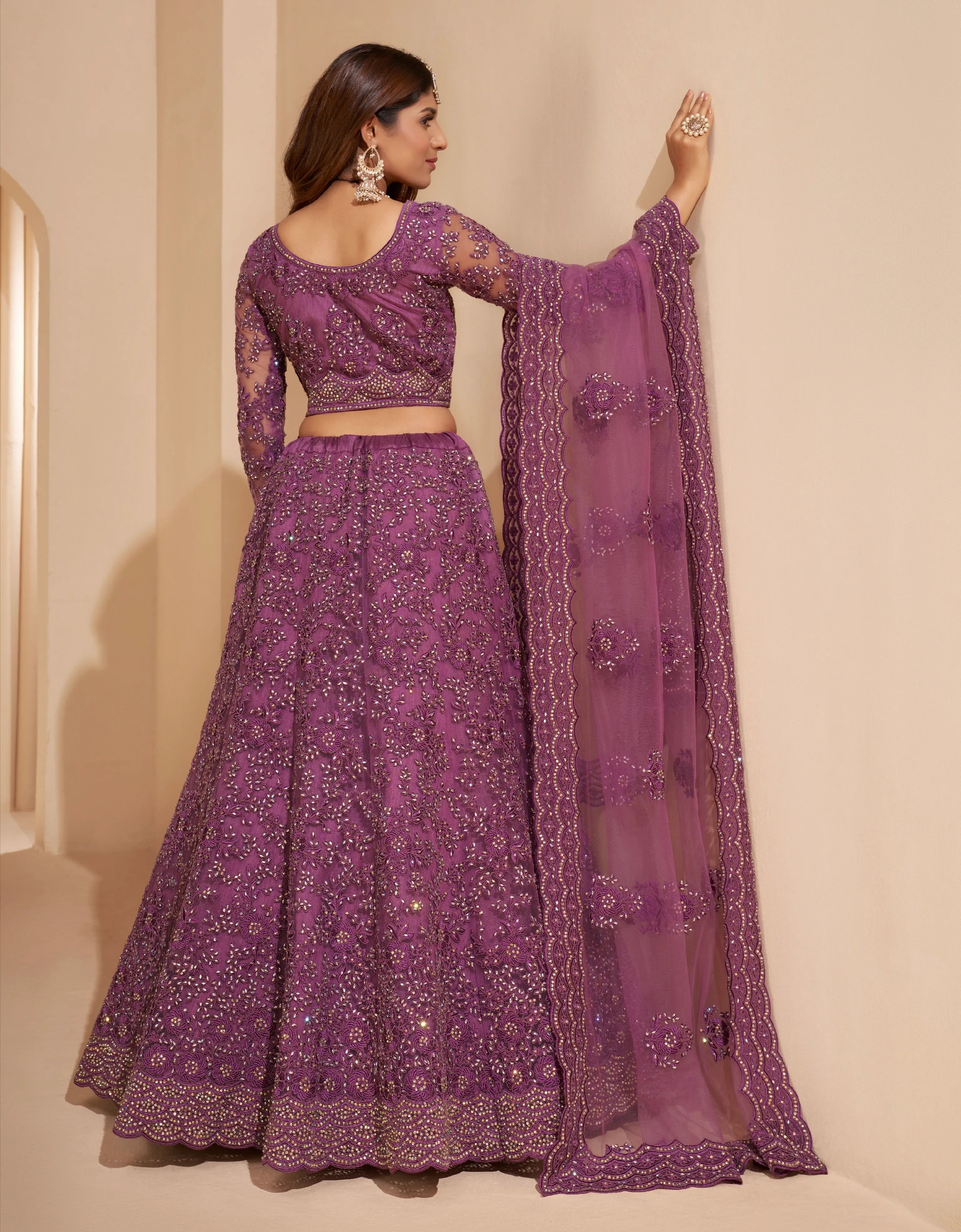 Elegant dark orchid net lehenga with silk inner and thread &amp; cording embroidery.