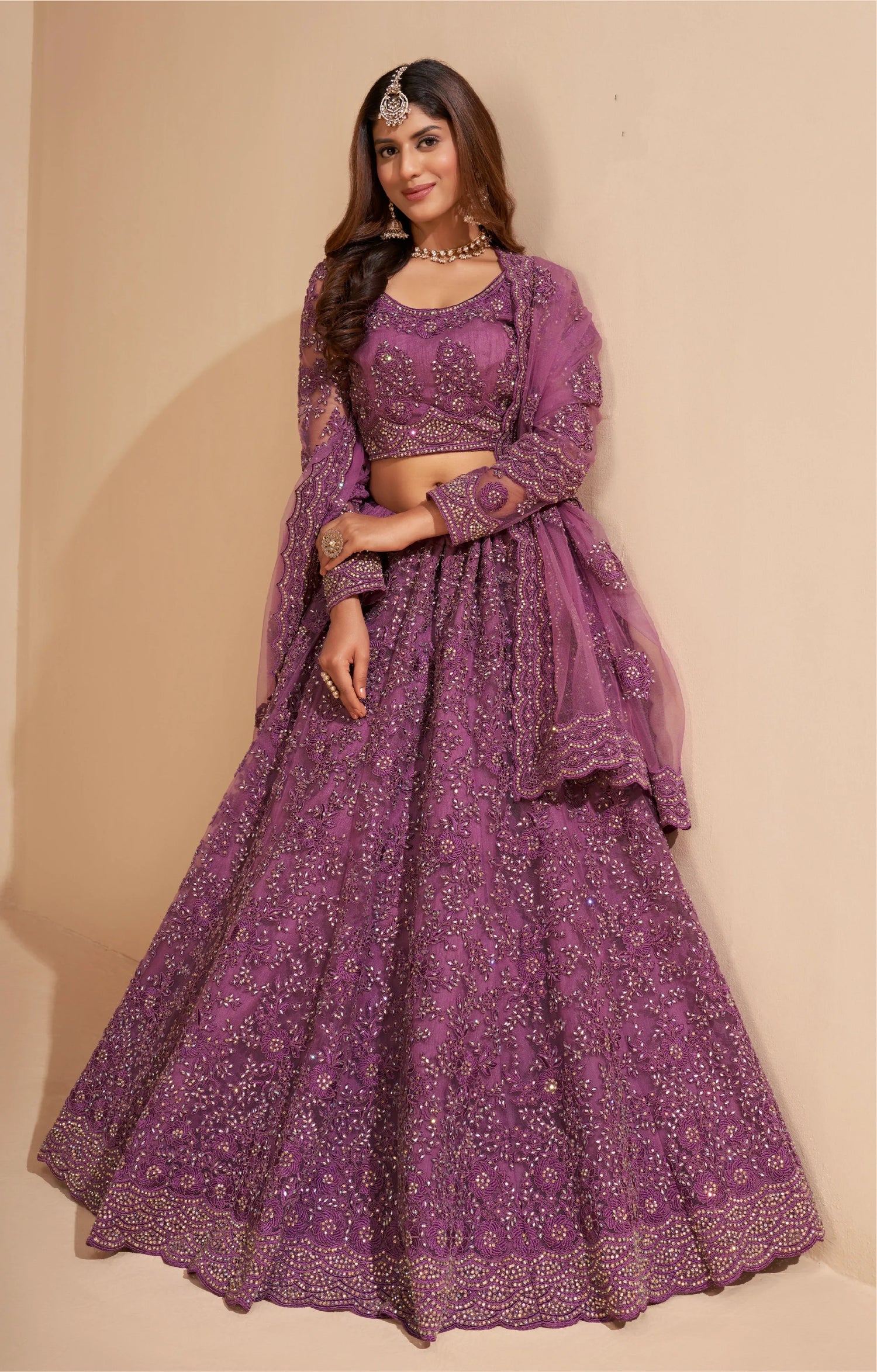 Elegant dark orchid net lehenga with silk inner and thread &amp; cording embroidery.