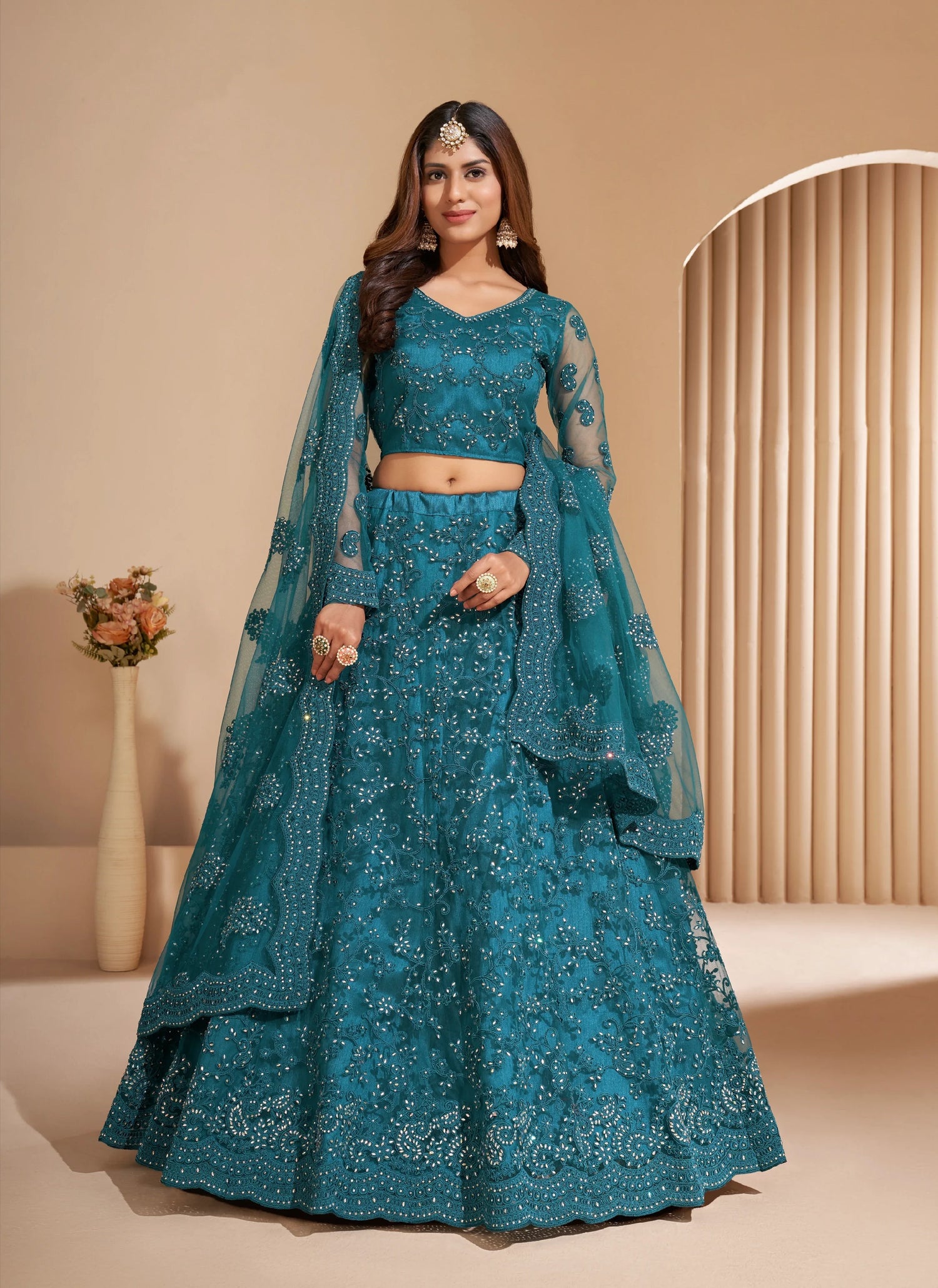 Elegant teal net lehenga with silk inner and thread &amp; cording embroidery.