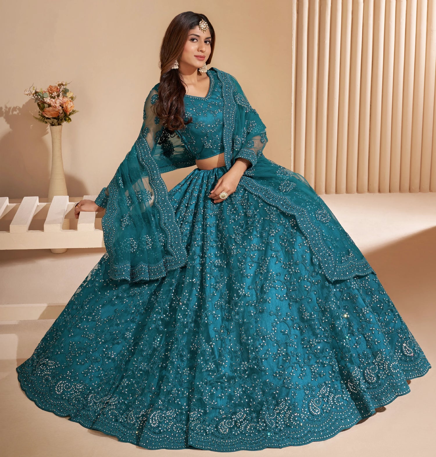 Elegant teal net lehenga with silk inner and thread &amp; cording embroidery.