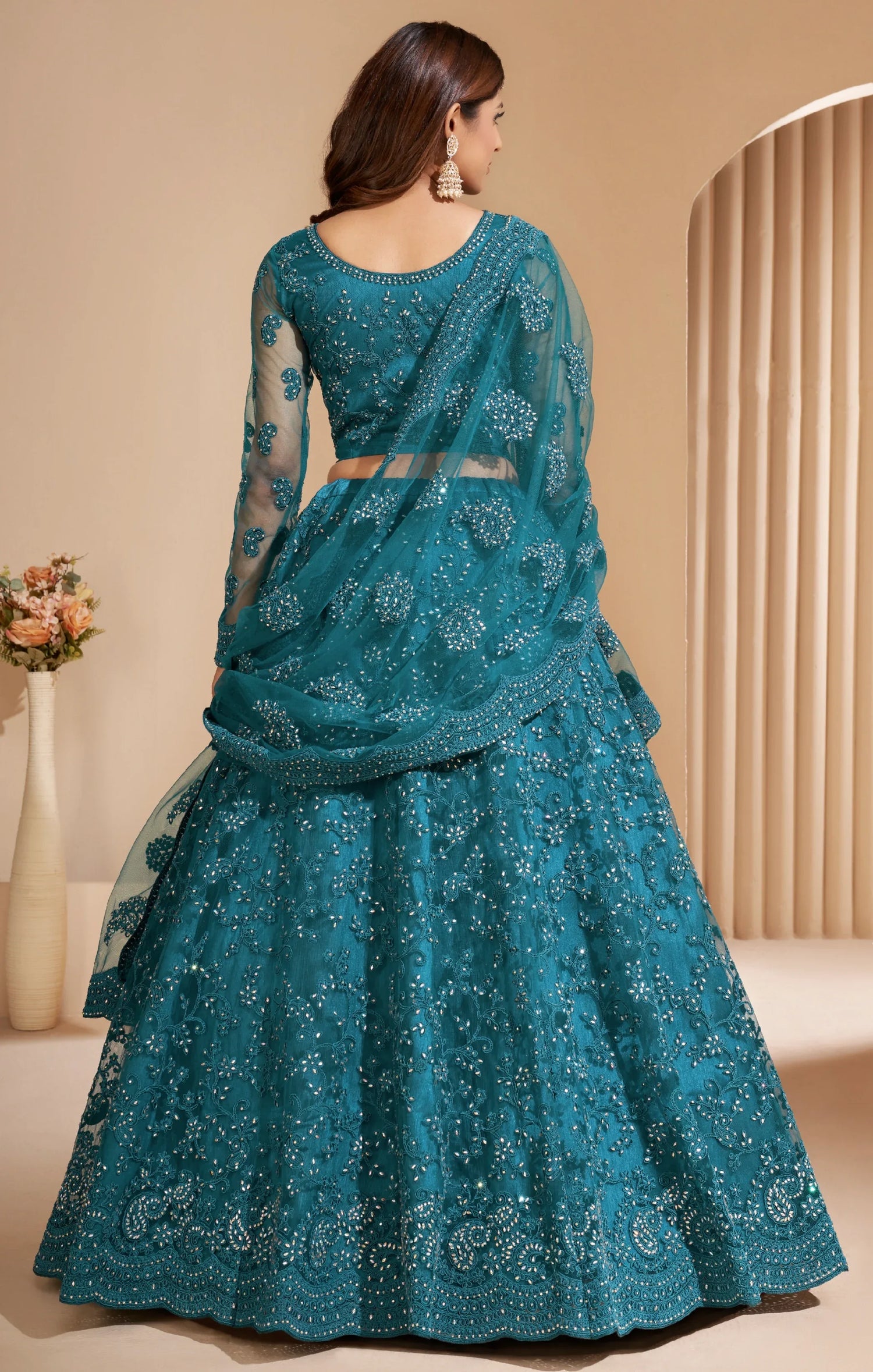 Elegant teal net lehenga with silk inner and thread &amp; cording embroidery.