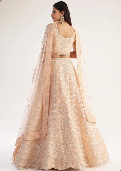 Elegant peach bridal lehenga with ribbon gota work and heavy zarkan embellishments.