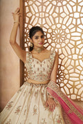 Traditional white silk wedding lehenga featuring zari work and contrasting pink dupatta