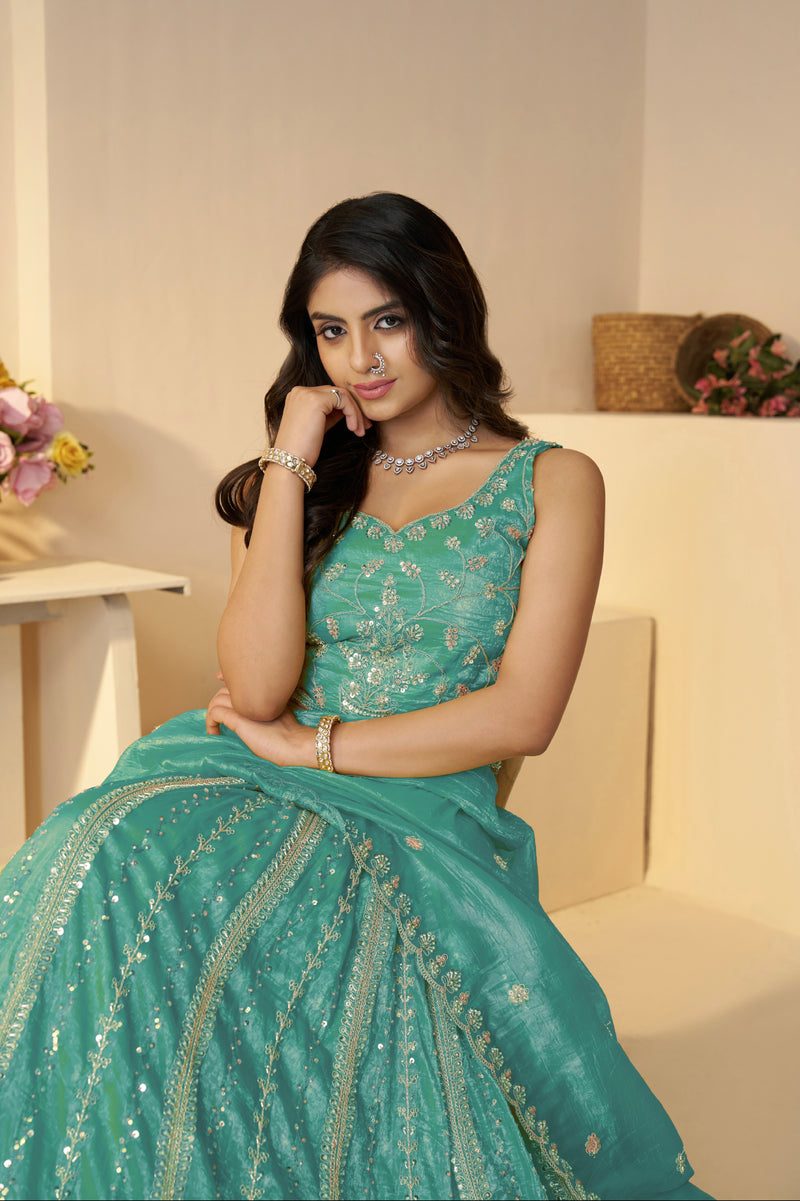 Close-up of intricate zari, peacock, and floral embroidery on sky blue lehenga

