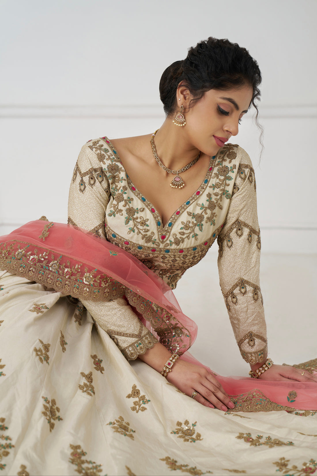 White zari silk bridal lehenga with contrasting pink dupatta and intricate embroidery